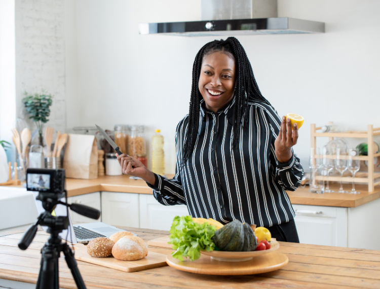 Happy lady cooking in the kitchen with a camera