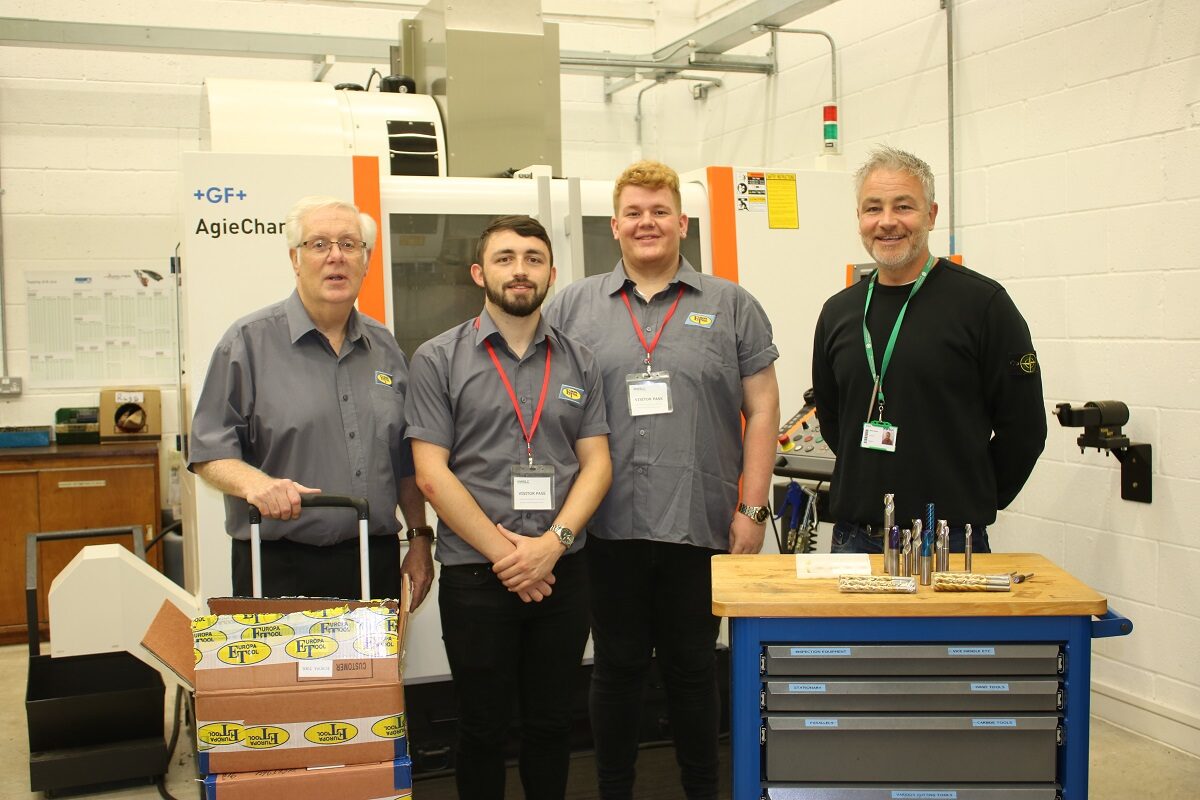 Photo of four men in engineering workshop