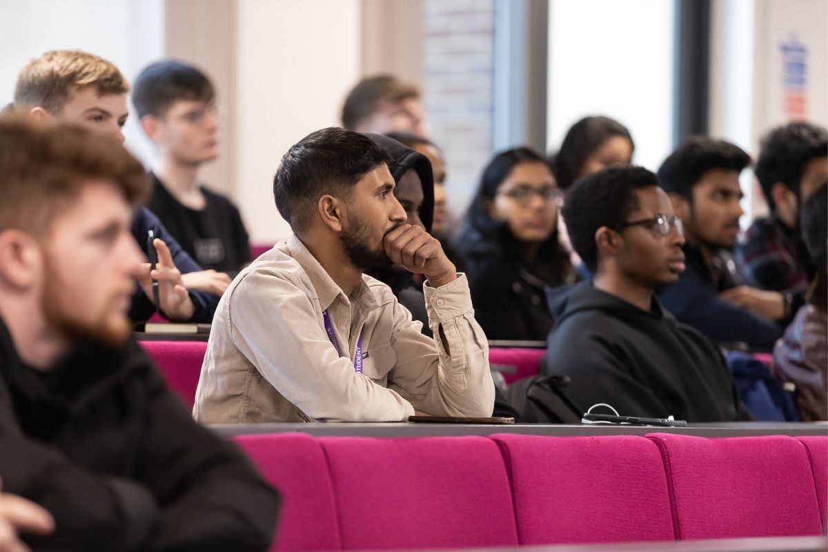 male student listening in lecture theatre