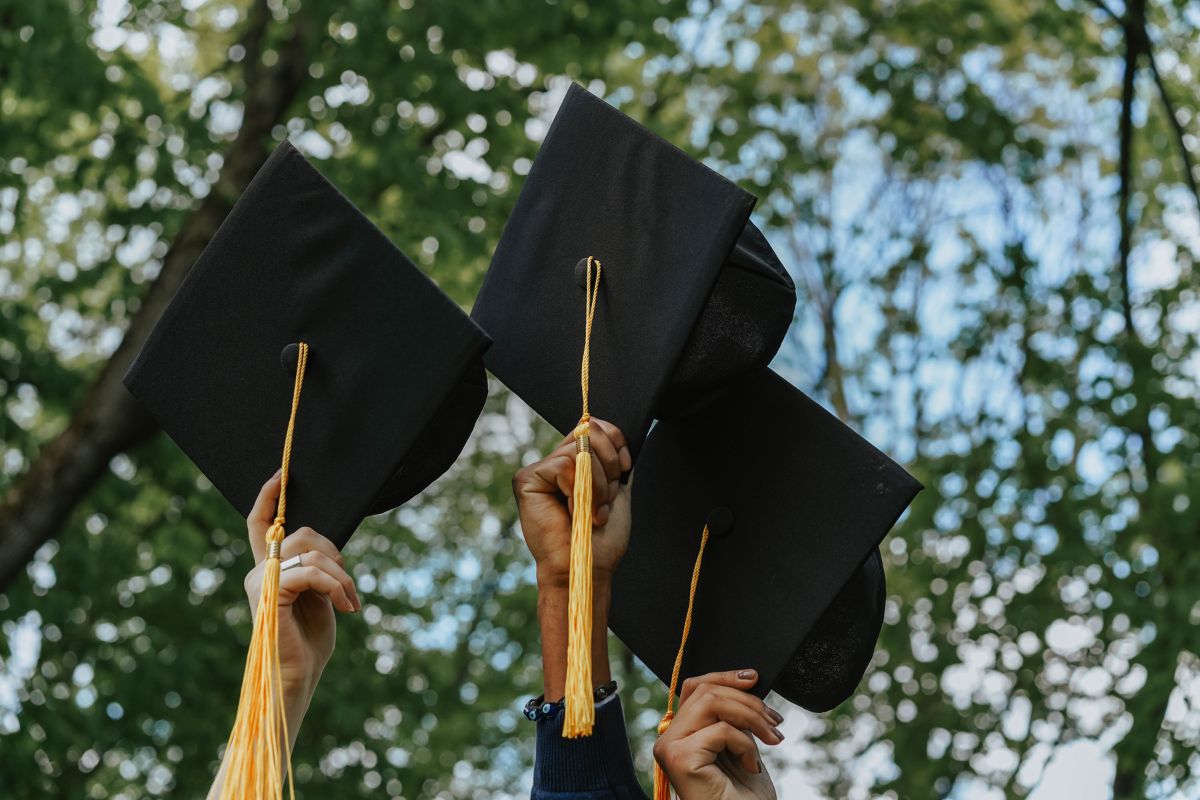 graduates holding hats in the air