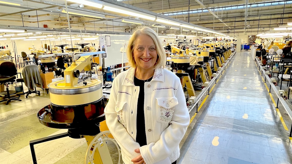 Photo of Jan Young standing in a knitwear factory.