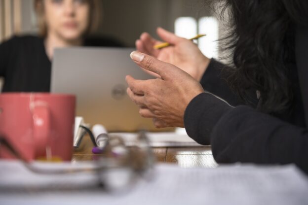 Close up of hands with a blurred female face in the background