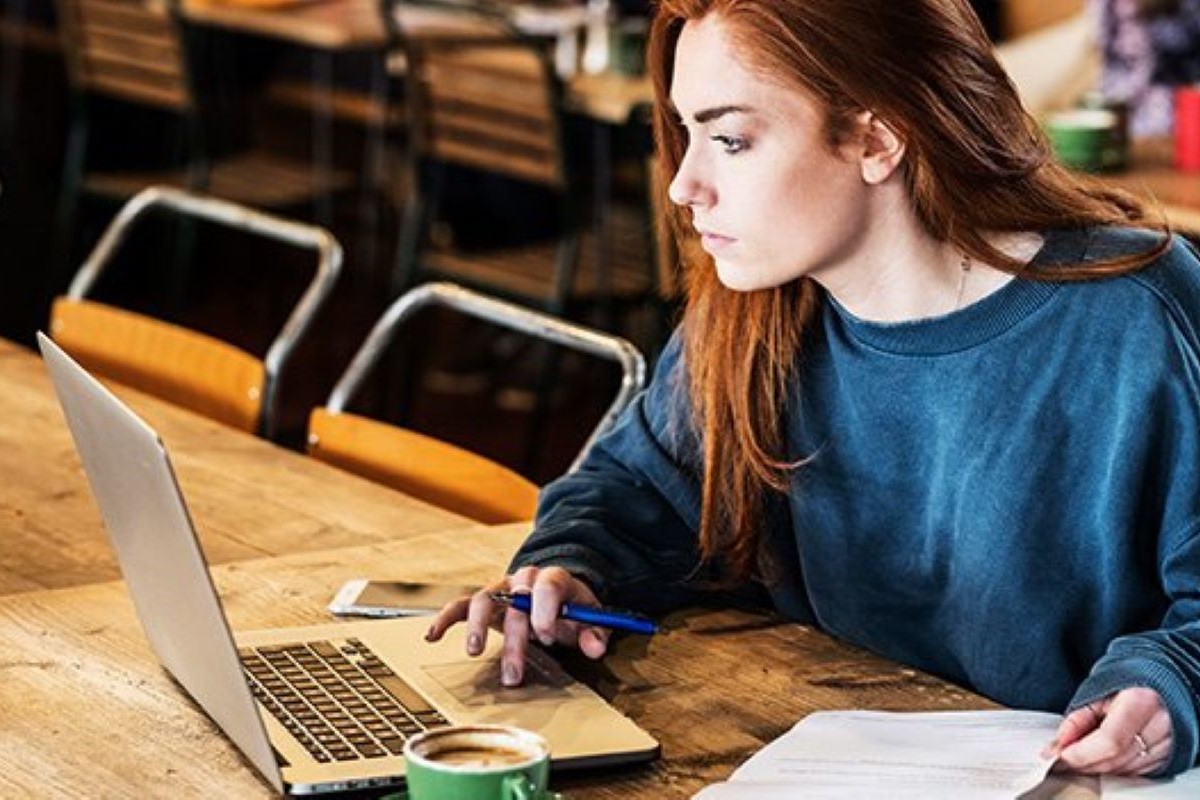 woman looking at laptop in cafe