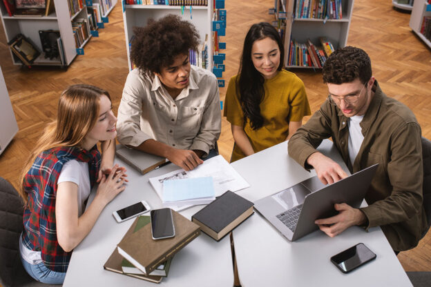 Students studying together at a table in a library