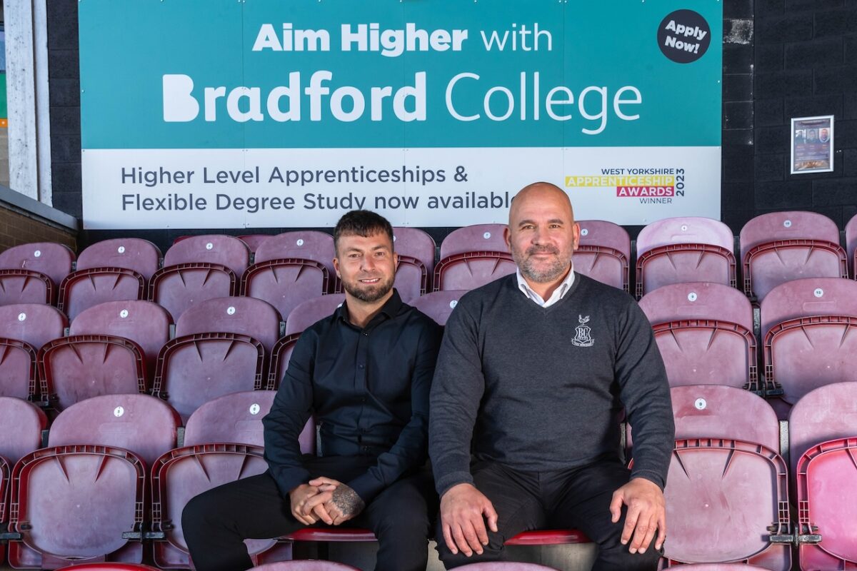 Nicky Betteridge, the Bradford College Apprenticeships & Business Development Team Leader, sits to the left of David Longo -Bradford City AFC Chief Commercial Officer. The men are sat in the football ground stands with a Bradford College banner behind them.