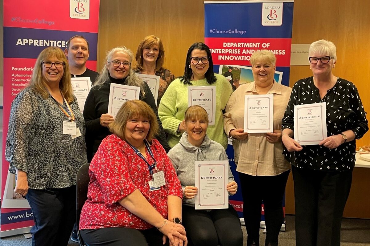 Group of candidates holding course completion certificates