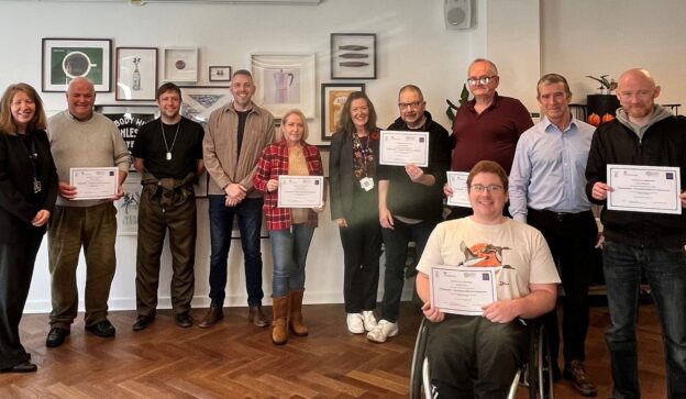 Group of candidates holding course completion certificates