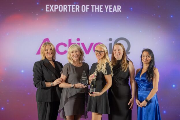 Five colleagues from Active IQ stand smiling and holding the FAB Award trophy