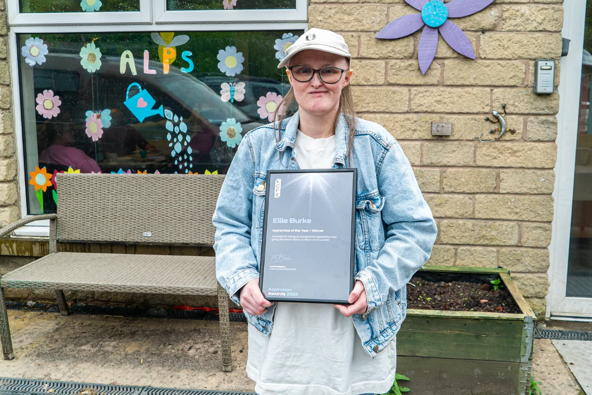 Ellie Burke standing outside holding her award