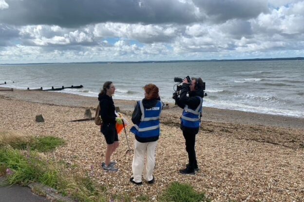 Graduates James Roualt and Marnie Evans filming the beach clean at Hill Head