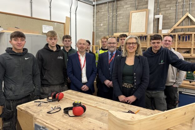 MSP Rachael Hamilton standing with a group of construction students in a joinery workshop