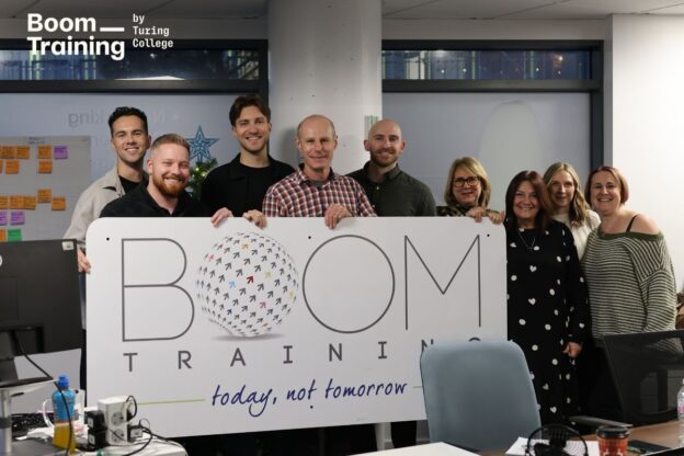 Group photo of Boom CEO Andrew Hooper with Turing College leaders Lukas Kaminskis, Benas Šidlauskas, and Scott, taken during the announcement of Boom’s acquisition of Turing College.