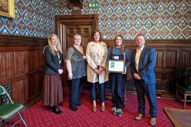 Elizabeth receiving her Keith Fletcher award in Parliament with her tutor and AIM's Access to HE team, and CEO