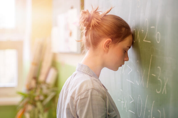 Teenager girl in math class overwhelmed by the math formula. Pressure, Education, Success concept.