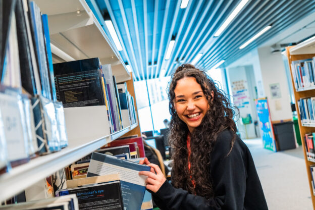 Student looks through books in the library